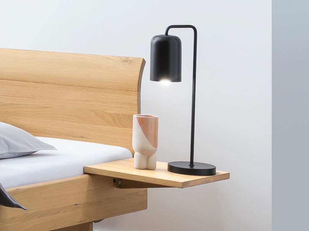 braune bettablage in form eines einfachen brettes angebracht am rahmen eines holzbettes stilvoll dekoriert in einem hellen zimmer mido von hasena