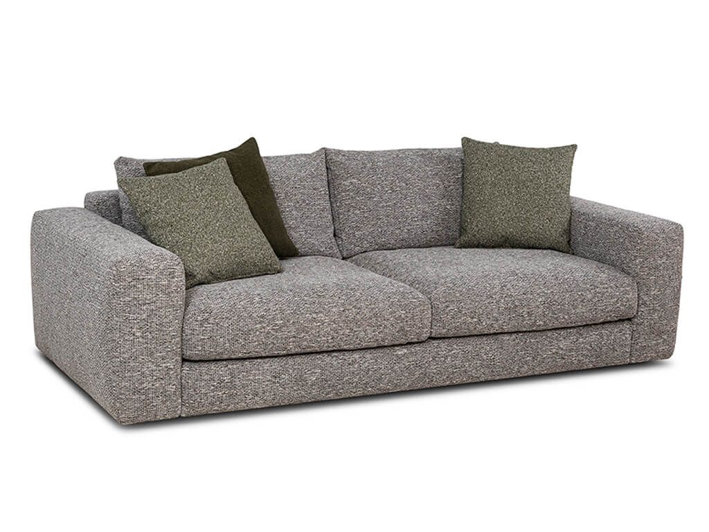 Ein leicht schräg von vorne dargestelltes, beiges Stoffsofa mit strukturierter Oberfläche und vier Zierkissen, zwei in Hellgrün und zwei in dunklem Olivgrün.