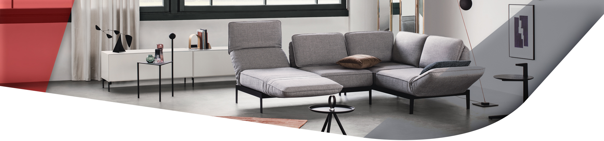 graue Couch mit verstellbaren Arm und Rückenlehnen im Wohnzimmer mit weißem Lowboard im Hintergrund